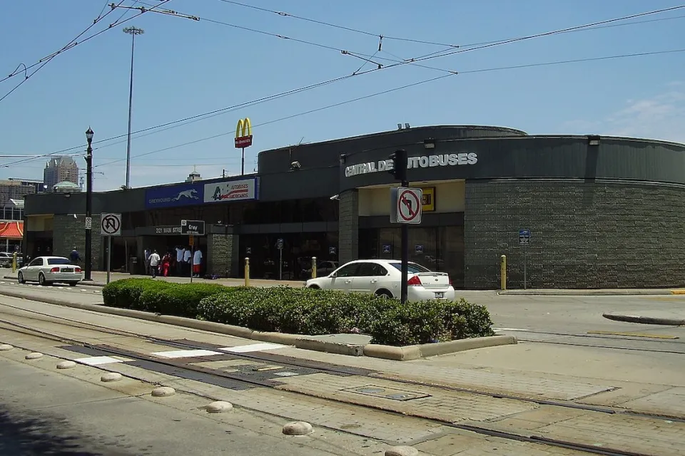 Greyhound bus station in Houston, Texas next to street with light rail tracks.